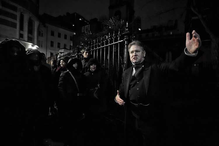 Richard Jones with a ghost walk group by a church railing.